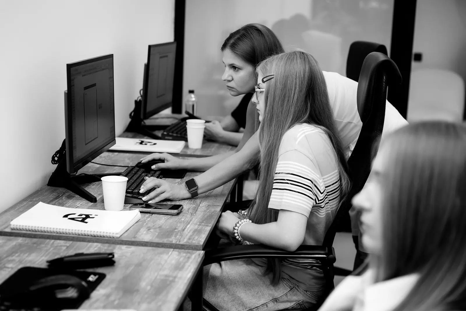 Преподаватель помогает студентке работать над проектом